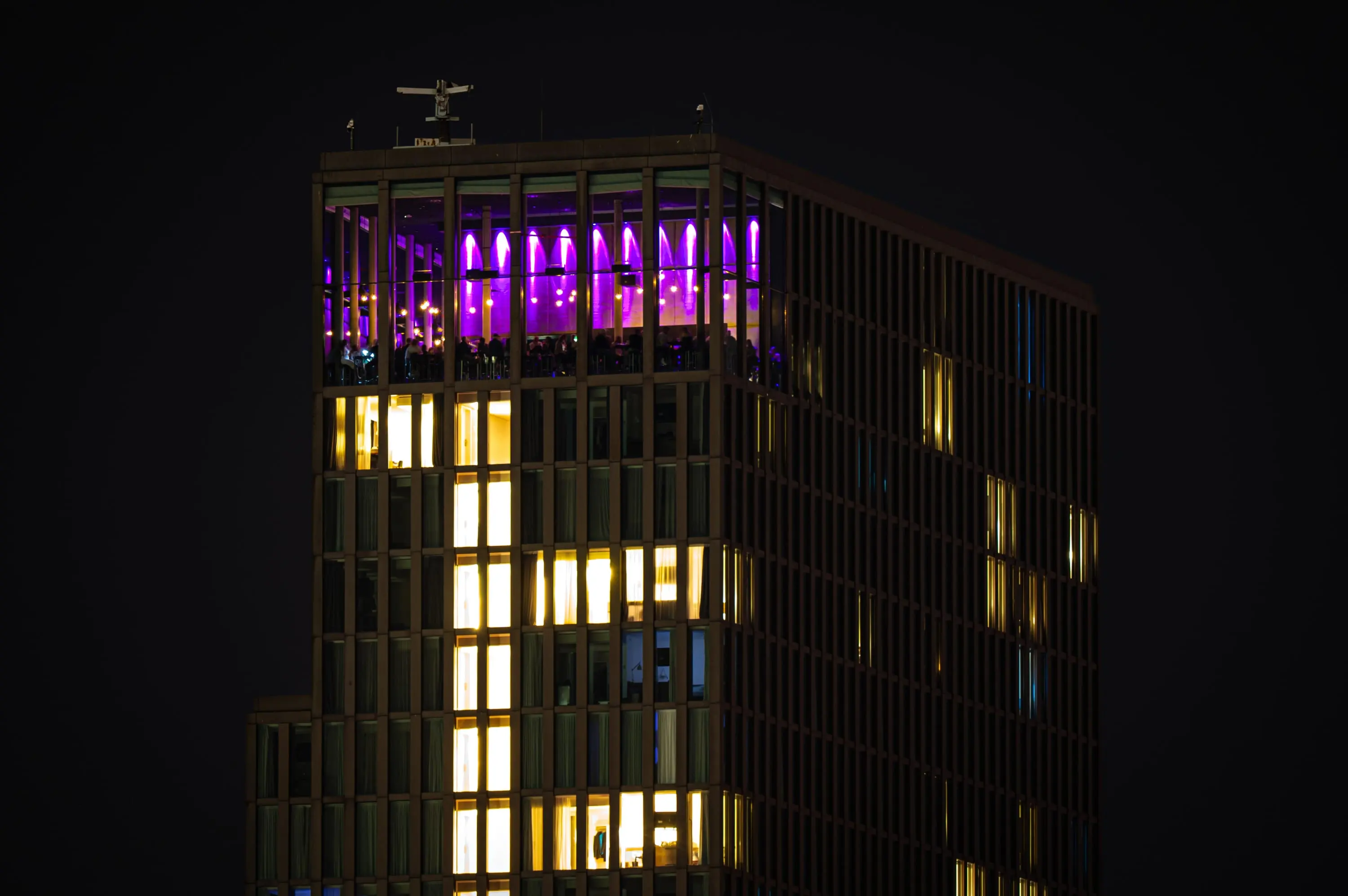 Rooftop bar overlooking the lit skyline