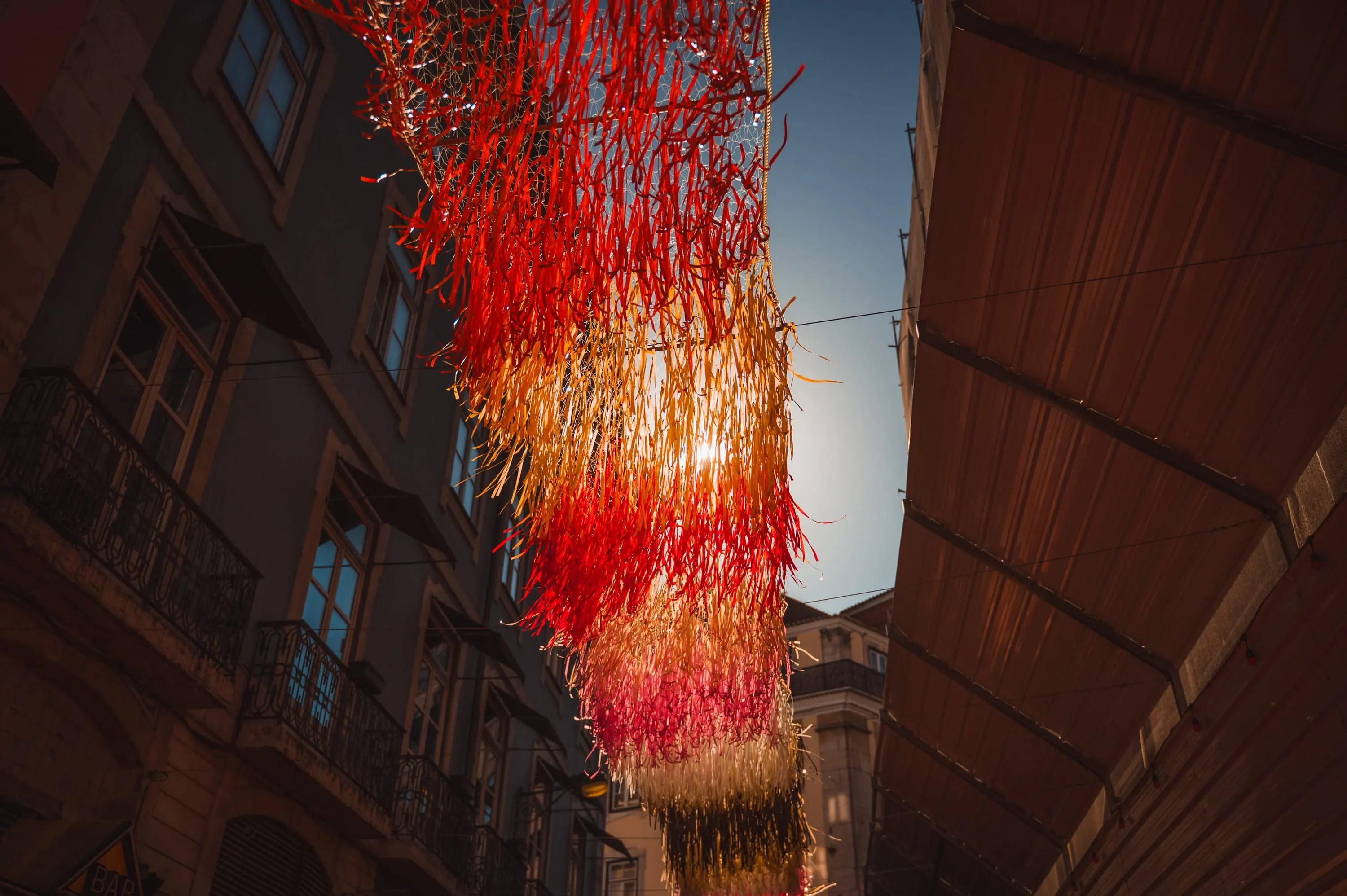 String lights over a Lisbon alley in the evening sun